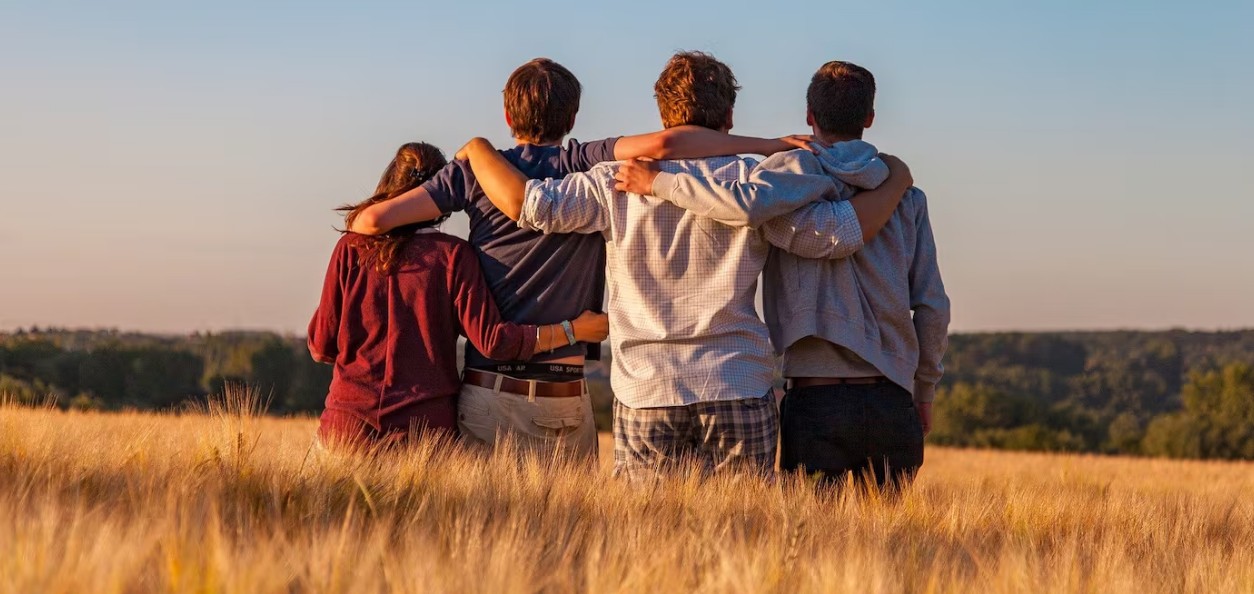Personas usando teléfonos móviles mientras conviven con amigos.