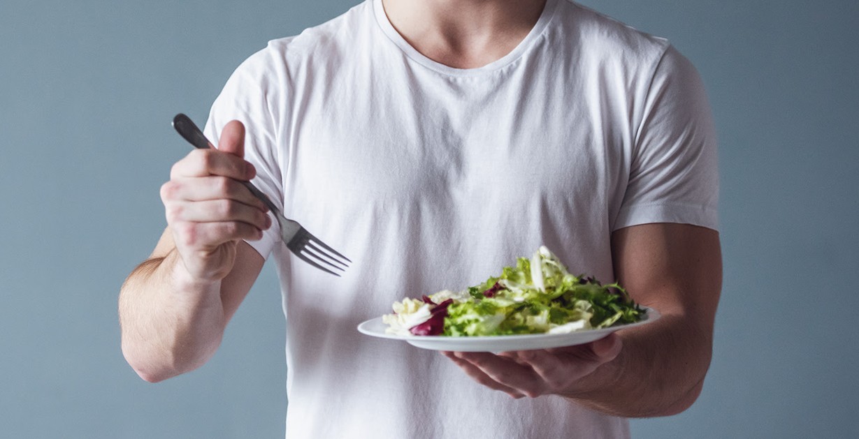 Persona realizando ejercicio de fuerza y comiendo alimentos saludables.