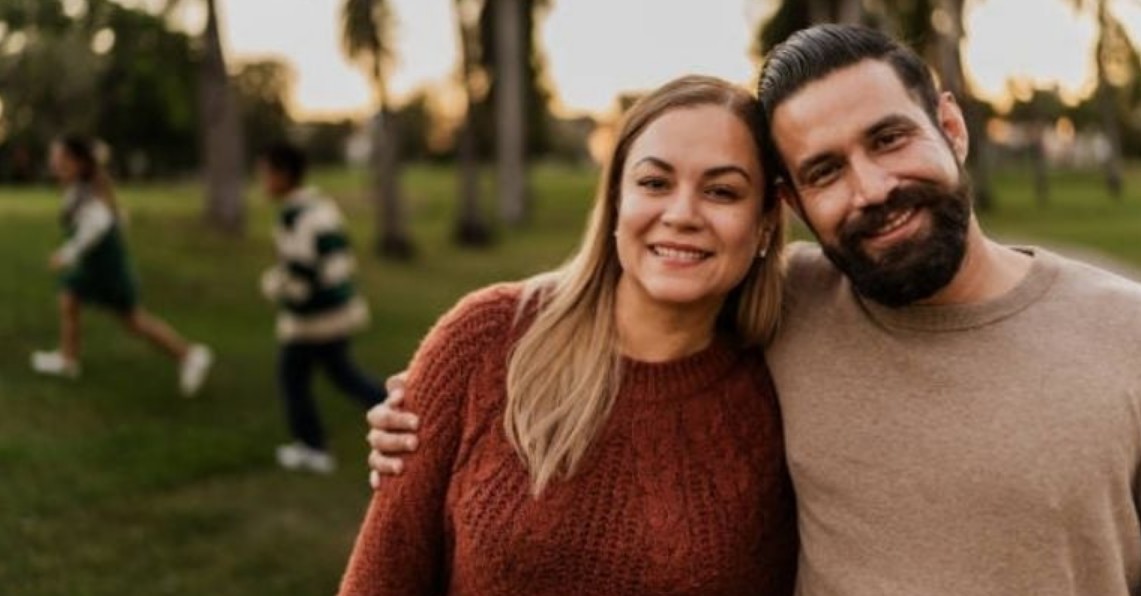 Pareja conversando y sonriendo en un parque.